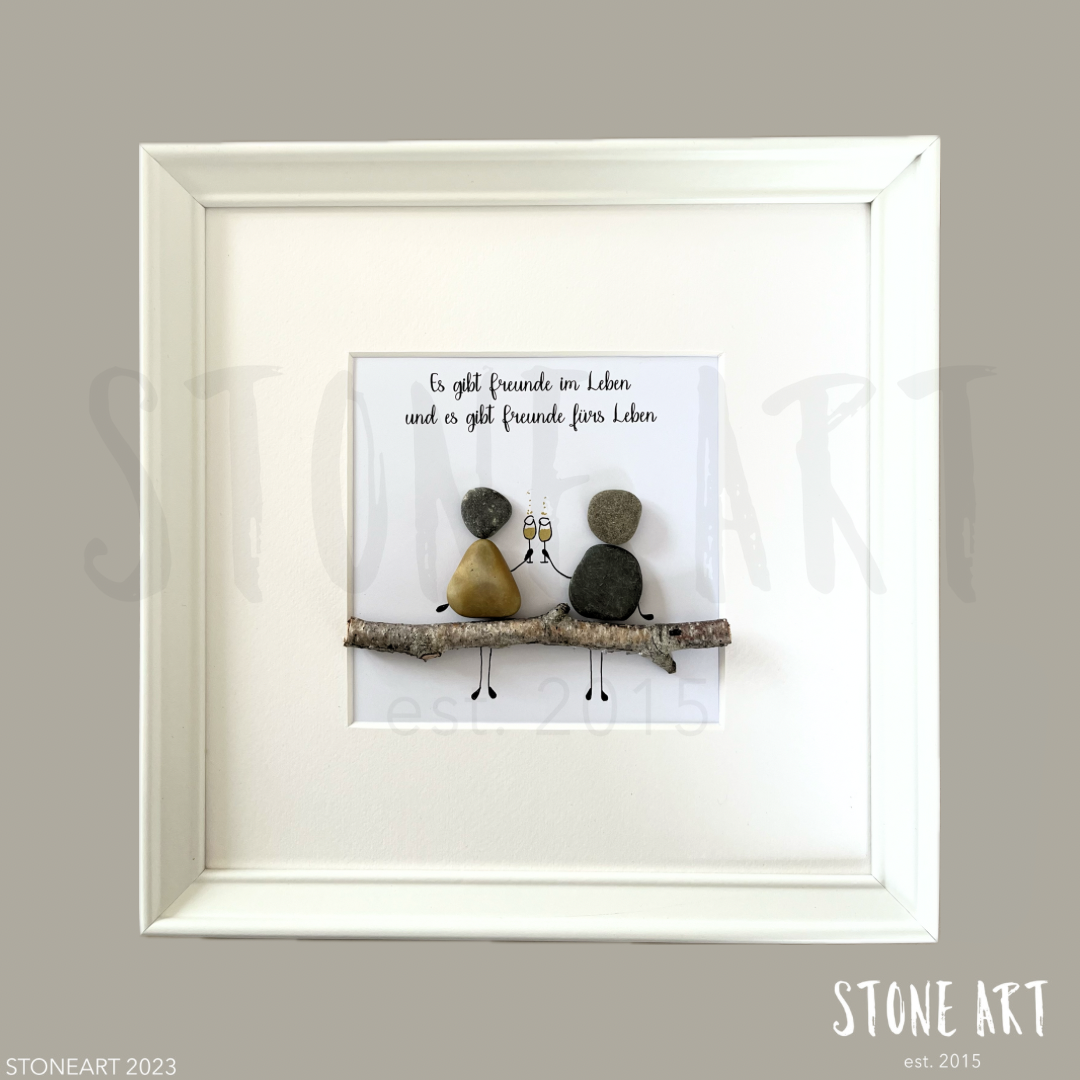 Handgefertigtes Steinbild mit Spruch 'Es gibt Freunde im Leben und es gibt Freunde fürs Leben' im weißen Rahmen