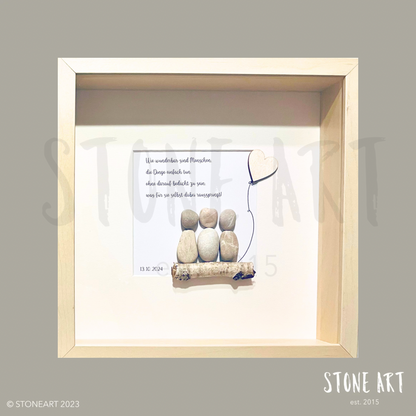 Handgefertigtes Steinbild auf rustikalem Treibholz: Zwei kleine Figuren aus Stein und Draht sitzen nebeneinander, daneben der Schriftzug „Wie wunderbar sind Menschen, die einfach Dinge tun.“ Schlichte, natürliche Materialien vermitteln Wärme und Inspiration.