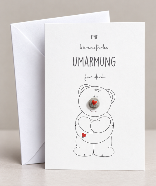 Handgemachte weiße Klappkarte mit Kieselstein, mit Spruch „Eine bärenstarke Umarmung für dich" und Bär