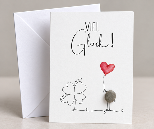 Handgemachte weiße Klappkarte mit Kieselstein, mit Spruch „Viel Glück" und Vogel