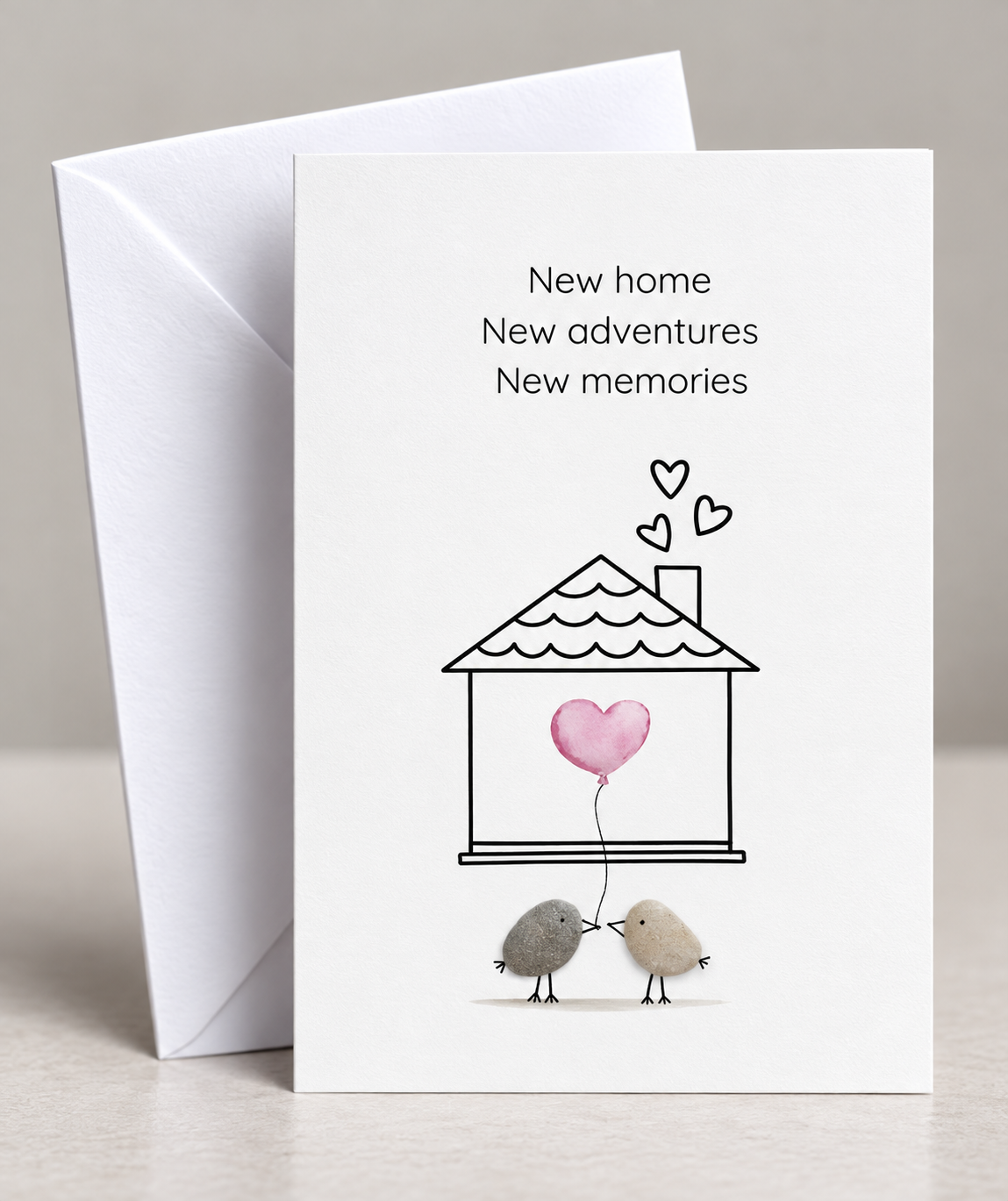 Handgemachte weiße Klappkarte mit Kieselstein, mit Spruch „New home, new adventures, new beginnings"