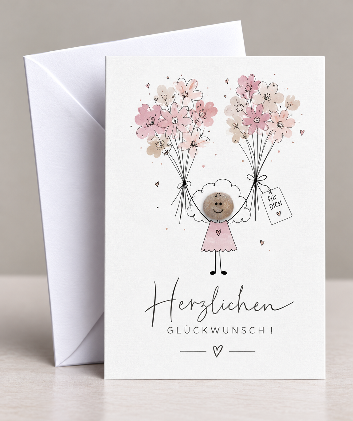 Handgemachte weiße Klappkarte mit Kieselstein, mit Spruch „Herzlichen Glückwunsch" und Mädchen mit Blumen
