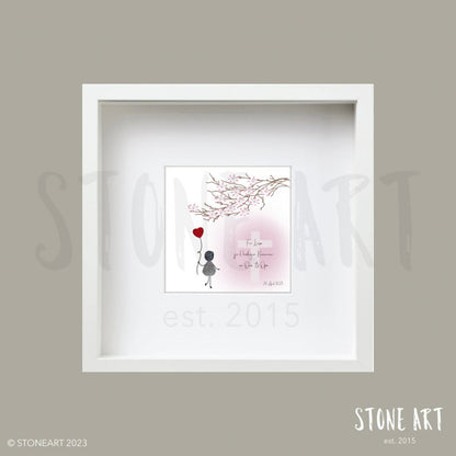 Ein gerahmtes Steinbild von Stoneart2015, das eine Figur aus Steinen darstellt, die einen Herzluftballon in der Hand hält. Oberhalb der Figur ist ein Kirschblütenzweig und unterhalb ein weißßes Kreuz mit einer rosa Umrandung auf der der Text lautet: "Für Laura zur Heiligen Kommunion von Oma und Opa 20.April 2024." Dieses Kunstwerk ist eine besondere, personalisierbare Geschenkidee zur Kommunion, Konfirmation oder Firmung. 