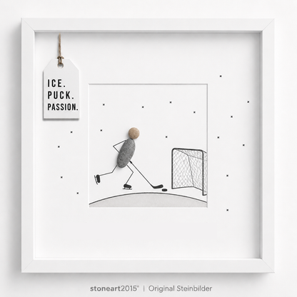 Steinbild mit einem Eishockeyspieler aus Kieselsteinen mit Schläger und Puck vor einem gezeichneten Tor, Schriftzug Ice Puck Passion