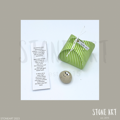 Handgefertigter Schmunzelstein von Stoneart2015 in Form eines kleinen Steins mit einem fröhlichen Gesicht. Der Stein dient als Glücksbringer, Trostspender und Mutmacher – ideal als kleines Geschenk oder Mitbringsel.