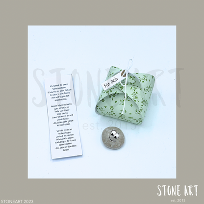Handgefertigter Schmunzelstein von Stoneart2015 in Form eines kleinen Steins mit einem fröhlichen Gesicht. Der Stein dient als Glücksbringer, Trostspender und Mutmacher – ideal als kleines Geschenk oder Mitbringsel.