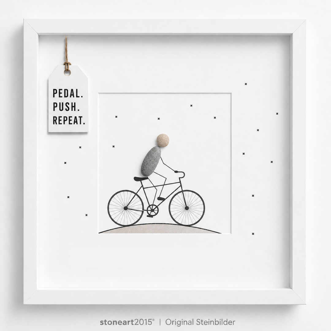 Steinbild mit einem Radfahrer aus Kieselsteinen auf einem gezeichneten Fahrrad, kleine Sterne, Schriftzug Pedal Push Repeat