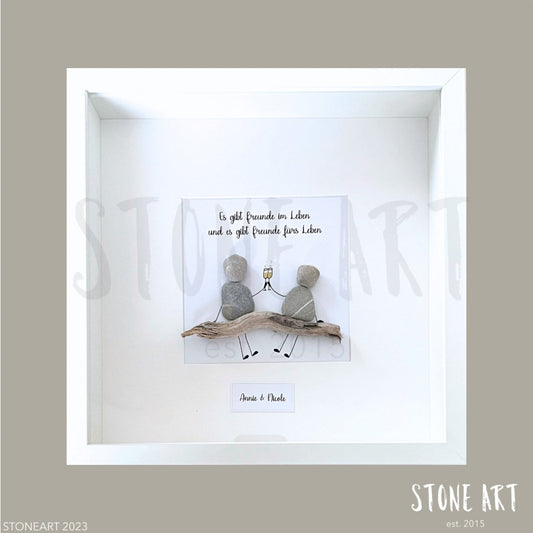 Handgefertigtes Steinbild mit Spruch 'Es gibt Freunde im Leben und es gibt Freunde fürs Leben' im weißen Rahmen