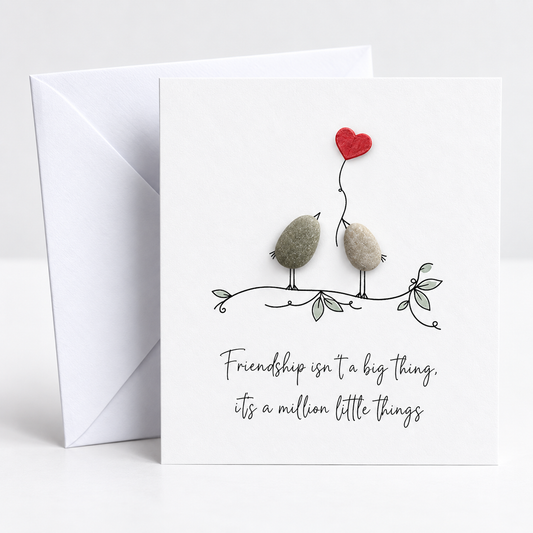 Handgemachte weiße Klappkarte mit zwei Kieselstein-Vögeln auf einem Zweig und rotem Herzballon, Spruch „Friendship isn’t a big thing, it’s a million little things“ – Freundschaftskarte, Grußkarte mit Umschlag