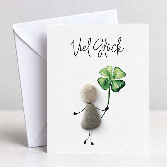Handgemachte weiße Klappkarte mit Kieselstein-Figur und Kleeblatt, Spruch „Viel Glück“ – Glückwunschkarte zum Viel Glück wünschen, Grußkarte mit Umschlag