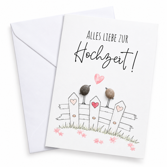 Handgemachte weiße Klappkarte mit zwei Kieselstein-Vögeln auf einem Holzzaun mit Herzen, Spruch „Alles Liebe zur Hochzeit!“ – Hochzeitskarte, Grußkarte mit Umschlag