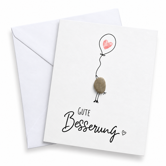 Handgemachte weiße Klappkarte mit Kieselstein-Vogel am Herzluftballon, Spruch „Gute Besserung“ – Genesungskarte, Grußkarte mit Umschlag