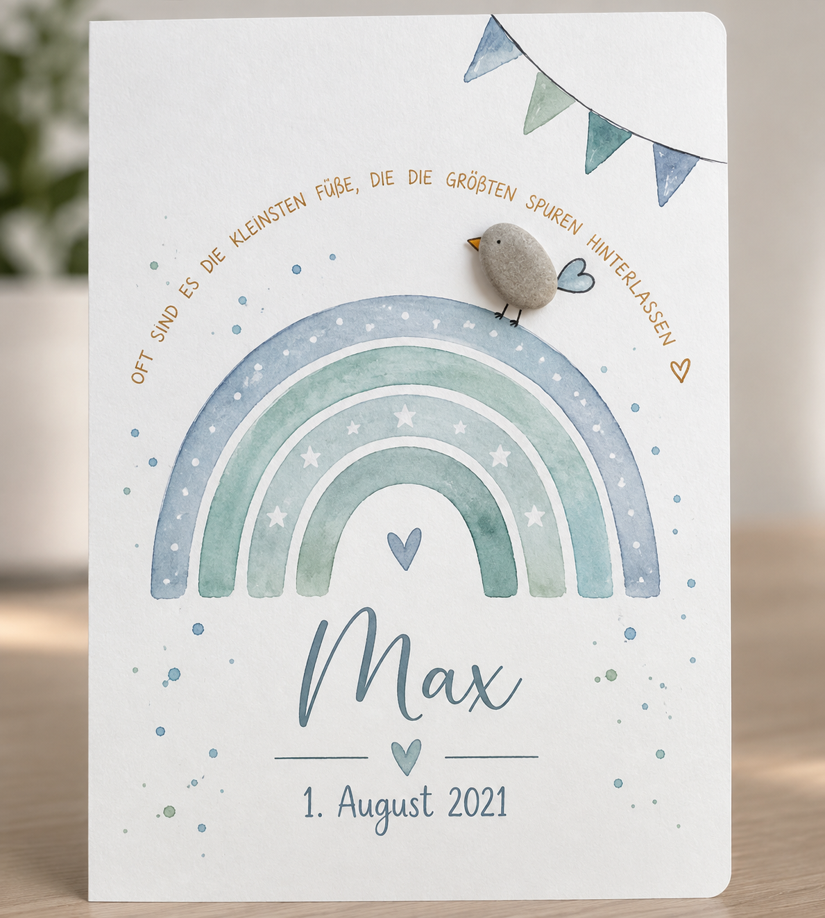 Handgemachte weiße Klappkarte mit Kieselstein-Vogel auf blauem Aquarell-Regenbogen, personalisiert mit Name und Geburtsdatum, Spruch „Oft sind es die kleinsten Füße, die die größten Spuren hinterlassen“ – Karte zur Geburt eines Jungen, Grußkarte mit Umschlag
