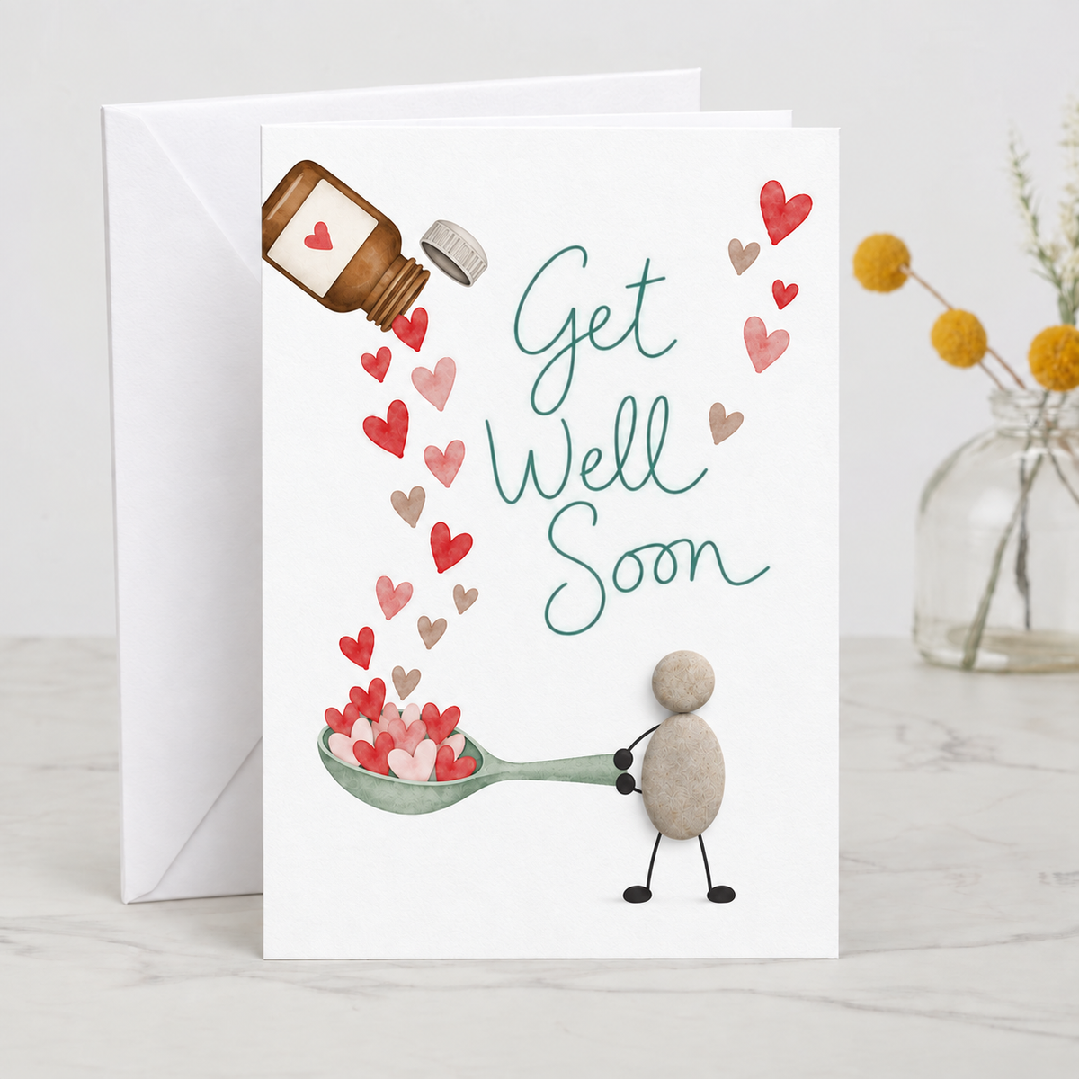 Handgemachte weiße Klappkarte mit Kieselstein-Figur, Löffel voller Herzen und Medizinfläschchen, Spruch „Get Well Soon“ – Genesungskarte für gute Besserung, Grußkarte mit Umschlag