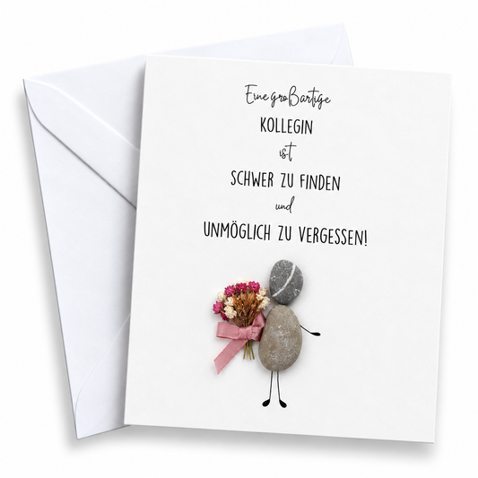 Handgemachte weiße Klappkarte mit Kieselstein-Figur und Trockenblumen-Strauß mit rosa Schleife, Spruch „Eine großartige Kollegin ist schwer zu finden und unmöglich zu vergessen!“ – Abschiedskarte für Kolleginnen, Grußkarte mit Umschlag