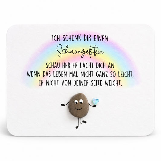 Handgemachte weiße Karte mit runden Ecken und Kieselstein-Figur unter einem Regenbogen, Spruch „Schmunzelstein“ – Affirmationskarte zum Mutmachen und Aufmuntern